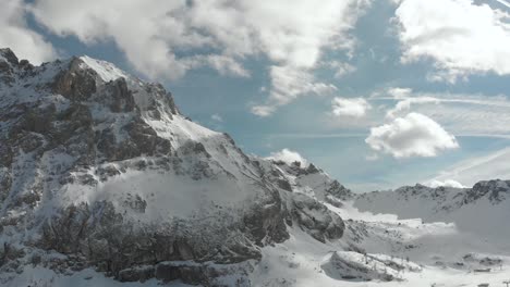 Dynamic-drone-shot-ideal-for-accelerating-into-a-snowy-Dolomites-timelapse,-with-moving-clouds,-featuring-Marmolada-and-Ciampac-ski-resort-area