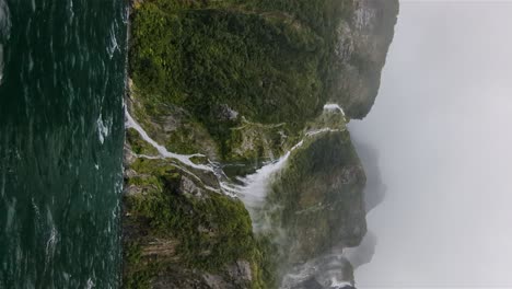 vertical-of-New-Zealand-Waterfalls-in-Milford-Sound-during-a-windy-hail-storm-rainy-season