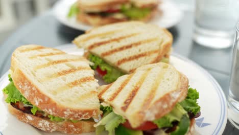 Delicious-toast-sandwiches-with-vegetables-on-white-plates,-close-up