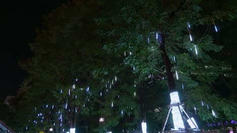 LED-lights-cascading-like-water-displayed-on-the-trees-by-the-sidewalk-for-the-celebration-of-the-Christmas-season-in-the-city-of-Bangkok,-Thailand