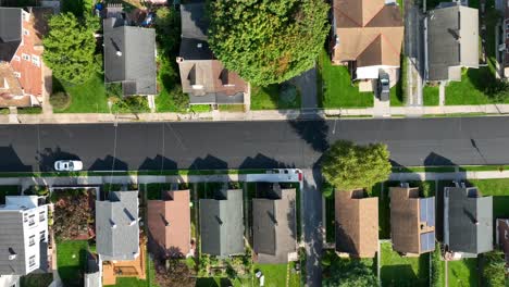 Bird's-eye-view-of-a-suburban-street-with-aligned-houses-and-tree-shadows