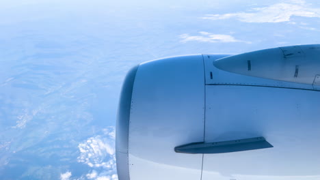 Malerische-Aussicht-Aus-Einem-Flugzeugfenster,-Wobei-Der-Flügel-Durch-Einen-Mit-Flauschigen-Wolken-Geschmückten-Himmel-Schneidet