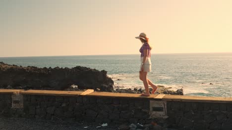 Young-woman-admires-sunset-sky-and-walks-away-in-Tenerife