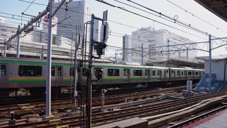 Japanese-Train-on-Yamanote-Line,-passing-station-on-Sunny-Day