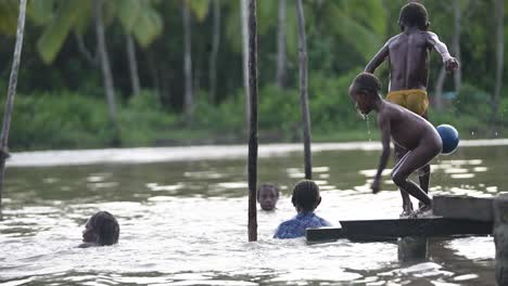 Papua-Kinder-Spielen-Und-Schwimmen-Im-Fluss-In-Asmat,-Papua