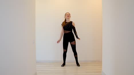 Zeitlupenclip-Einer-Attraktiven-Und-Energiegeladenen-Jungen-Kaukasischen-Tänzerin,-Die-Vor-Einem-Weißen-Hintergrund-In-Einem-Haus-Einen-Tanz-Aufführt