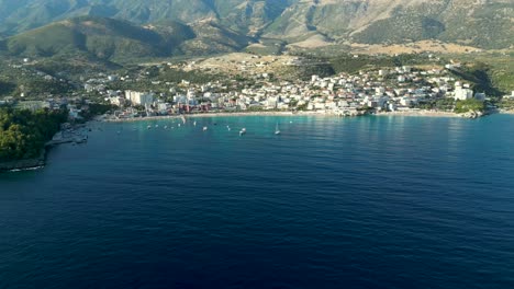 Kleine-Küstenstadt-Im-Süden-Albaniens-Mit-Kleinem-Strand-Und-Bergen-Im-Hintergrund