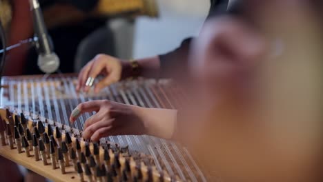 A-woman-playing-on-Zither-in-the-theatre-beside-a-man-playing-Oud-high-angle-shot,-close-up