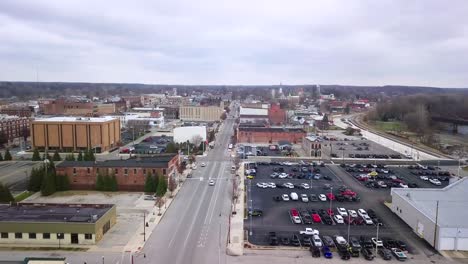 Logansport,-Indiana-aerial-view-flying-downtown-street-past-charming-white-church-with-spire-in-city-parish