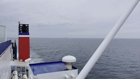 Shot-of-a-ship-on-an-ocean-in-Europe-looking-backwards-towards-the-horizon-with-a-chimney