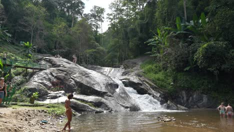 Touristen-Genießen-Ein-Bad-Am-Berühmten-Mo-Pang-Wasserfall,-Handgehaltener-Sommertag