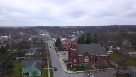 Aerial-view-flying-across-quiet-Sheridan-town-autumn-neighbourhood-towards-Indiana-Methodist-church