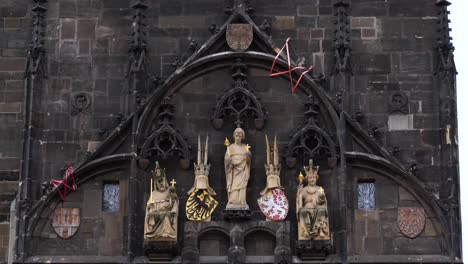 Detalle-De-Las-Estatuas-Y-Escudos-De-Armas-En-La-Torre-Del-Puente-De-La-Ciudad-Vieja-En-Praga,-República-Checa