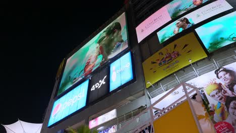 Digitale-Werbetafeln-Bewerben-Gleichzeitig-Verschiedene-Produkte-Vor-Einem-Einkaufszentrum-In-Einem-Geschäftszentrum-In-Bangkok,-Thailand
