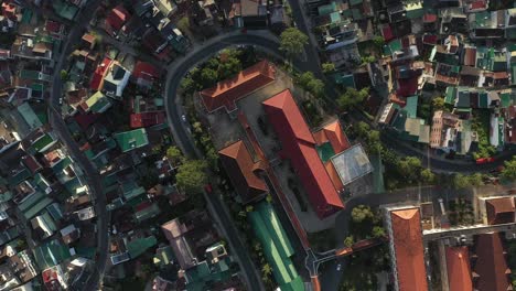 Dalat-City-or-Da-lat,-Vietnam-top-down-drone-shot-over-city-center-featuring-winding-roads-with-cars-and-motorbikes