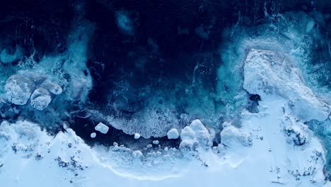 Aerial-view-of-waves-crashing-in-the-snowy-environment