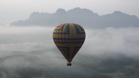 Colourful-Hot-Air-Balloon-Alone-Flight-Above-Dense-Clouds-At-Vang-Vieng,-Laos