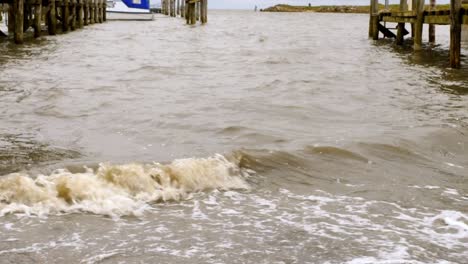 Close--up-of-waves-hitting-the-pier-of-a-small-harbor-in-Rantum,-Sylt