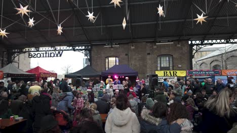 Crowds-Enjoying-Festive-Musical-Performance-By-Band-At-Canopy-Market-During-Christmas-In-December-At-Kings-Cross,-London