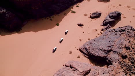 Aerial-View-of-SUV-Cars-Driving-on-the-Sahara-Desert-In-Tassili-n'Ajjer-National-Park-In-Djanet,-Algeria