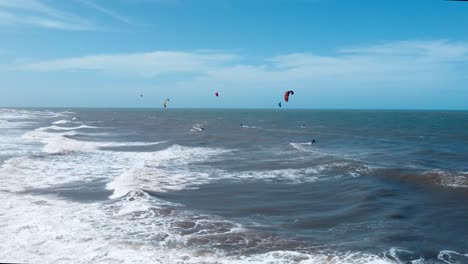 group-of-kitesurfer-riding-in-the-wavy-ocean