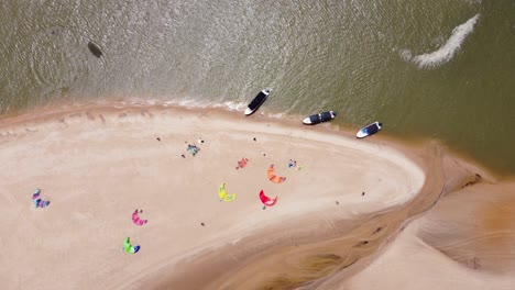 Birdseye-perspective-of-a-group-of-kiters-at-the-beach-preparing-there-kites