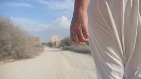Approaching-an-ancient-Greek-ruin,-slow-motion-following-a-woman-in-a-white-robe