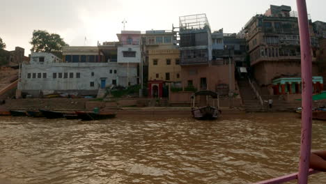 Cinematográfica-Varanasi-India-Río-Ganges-Canal-Barco-Crucero-Norte-Estado-Reunión-Antigua-Ciudad-Santa-Provincia-De-Ghat-Pradesh-Paisaje-Gris-Nublado-Tarde-Fangoso-Marrón-Izquierda