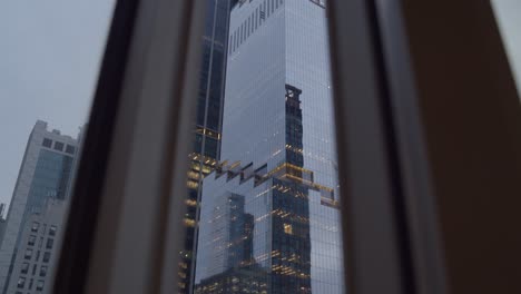 Tilt-down-establishing-shot-of-The-Spiral-66-Hudson-Boulevard-skyscraper-in-New-York-City---Midtown-Manhattan---apartment-window-POV---blue-hour