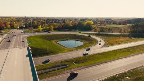 aerial-drone-shot-of-a-highway-overpass-entrance-and-exit-ramp-and-a-bridge-with-cars-moving-on-the-highway-on-a-sunny-day