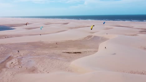 Gruppe-Von-Kitesurfern,-Die-Auf-Einer-Riesigen-Sandbank-In-Brasilien-Neben-Dem-Meer-Spazieren