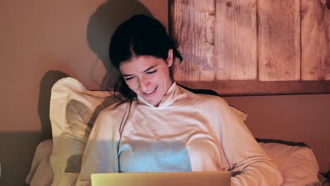 Happy-Laughing-Woman-Having-Conference-Via-Laptop-Computer,-Sitting-On-Bed