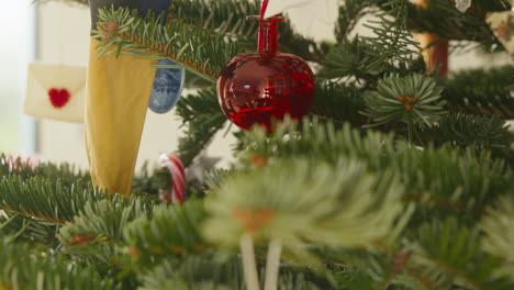 Rote-Weihnachtskugel-Hängt-An-Einem-Geschmückten-Tannenbaum