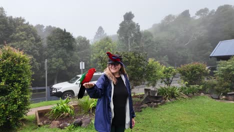 Female-tourist-interacts-with-tropical-birds-at-a-hinterland-getaway-on-a-misty-fog-covered-morning
