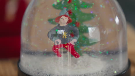 Close-up-of-a-Christmas-snow-globe-with-a-festive-character-and-tree