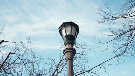 orbiting-shot-of-a-light-post-outside-of-a-home-on-a-winter-day-with-blue-skies