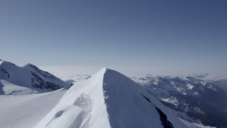 Drone-captures-the-majestic-Castor-ridge,-flying-towards-Punta-Felik,-revealing-alpinists-climbing