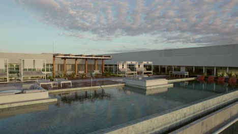 Pan-shot-of-a-modern-building-with-a-Luxurious-rooftop-terrace-with-a-pool-at-dusk