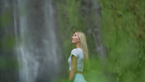 Female-traveler-enjoying-stunning-view-of-natural-waterfall-in-Madeira