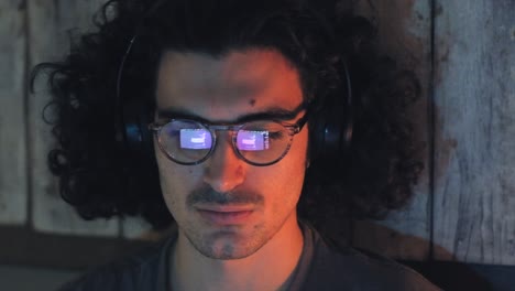 Man-Using-Computer-with-Glasses-Reflection-with-Headphones