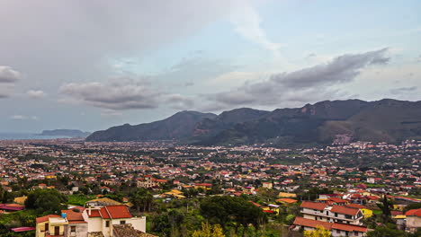 Sicilian-landscape-timelapse,-coastal-city-surrounded-by-mountains-in-Italy,-cloudy-day