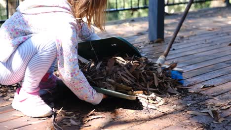 Two-girls-preparing-for-a-bushfire-by-clearing-leaves-off-a-deck