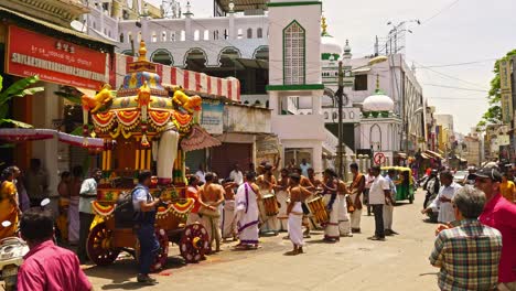 Worshipers-outside-a-Narasimha-Swamy-Hindu-temple-in-Bangalore,-India-preparing-a-shrine-while-musicians-beat-drums