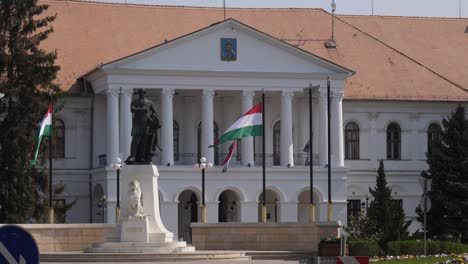 Mayor's-Office-in-Mako,-Hungary-with-the-statue-of-Kossuth-and-waving-Hungarian-flags