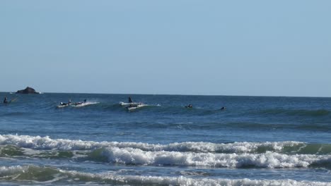 Varios-Surfistas-En-Trajes-De-Neopreno-Tratando-De-Subirse-A-La-Misma-Ola-De-Fiesta