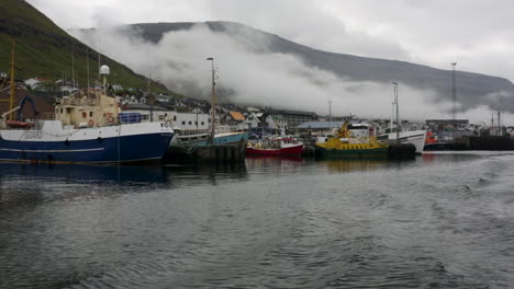 Barcos-De-Pesca-En-Un-Pequeño-Puerto-Con-Montañas-Nórdicas-Al-Fondo