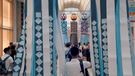 Gente-En-Arcade-Caminando-Entre-Serpentinas-De-Papel-Decorativas-Durante-El-Festival-De-Tanabata