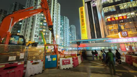 Timelapse-of-a-busy-street-and-mall-in-Hong-Kong-next-to-the-construction-site-that's-building-a-new-subway-station-As-people-rush-by,-the-elevators-in-the-mall-provide-texture