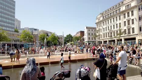 Families-and-people-from-all-walks-of-life-cool-off-on-a-hot-day-in-the-middle-of-an-English-heat-wave-in-the-fountains-at-the-Old-Market-Square,-Nottingham