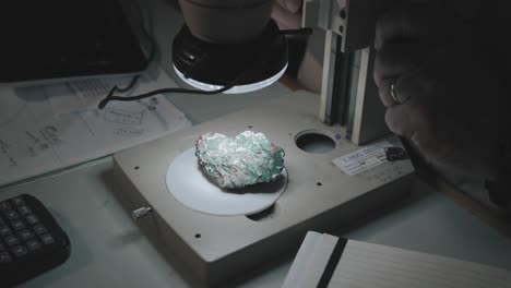 Mann-Schaut-Durch-Ein-Mikroskop-Auf-Eine-Gesteinsprobe